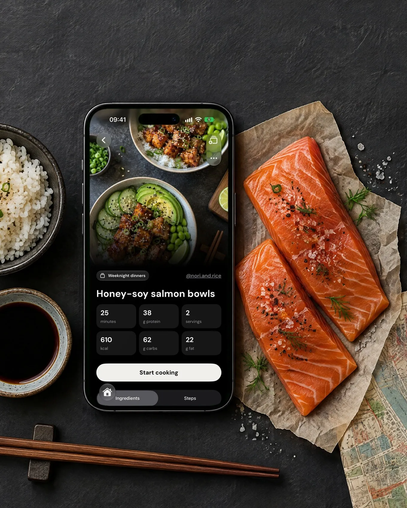 Ein iPhone auf einem dunklen Tisch zwischen Reis und rohem Lachs zeigt eine Smoosh-Rezeptkarte für Honig-Soja-Lachs-Bowls